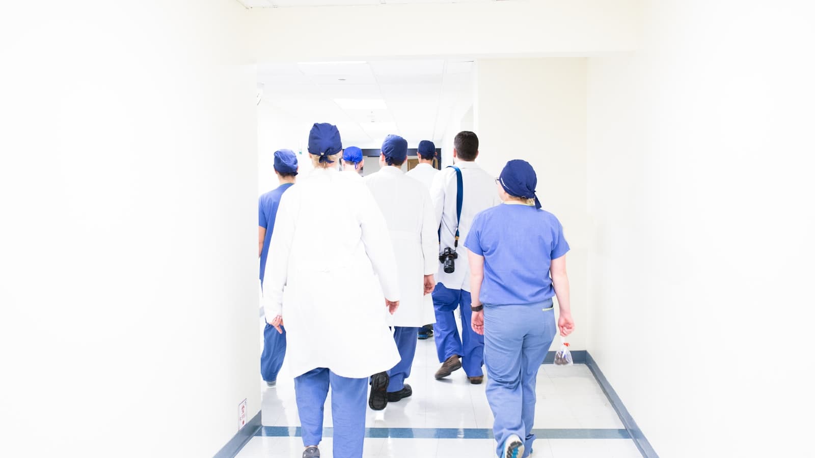 Doctors and clinical staff walking together in a hospital hallway