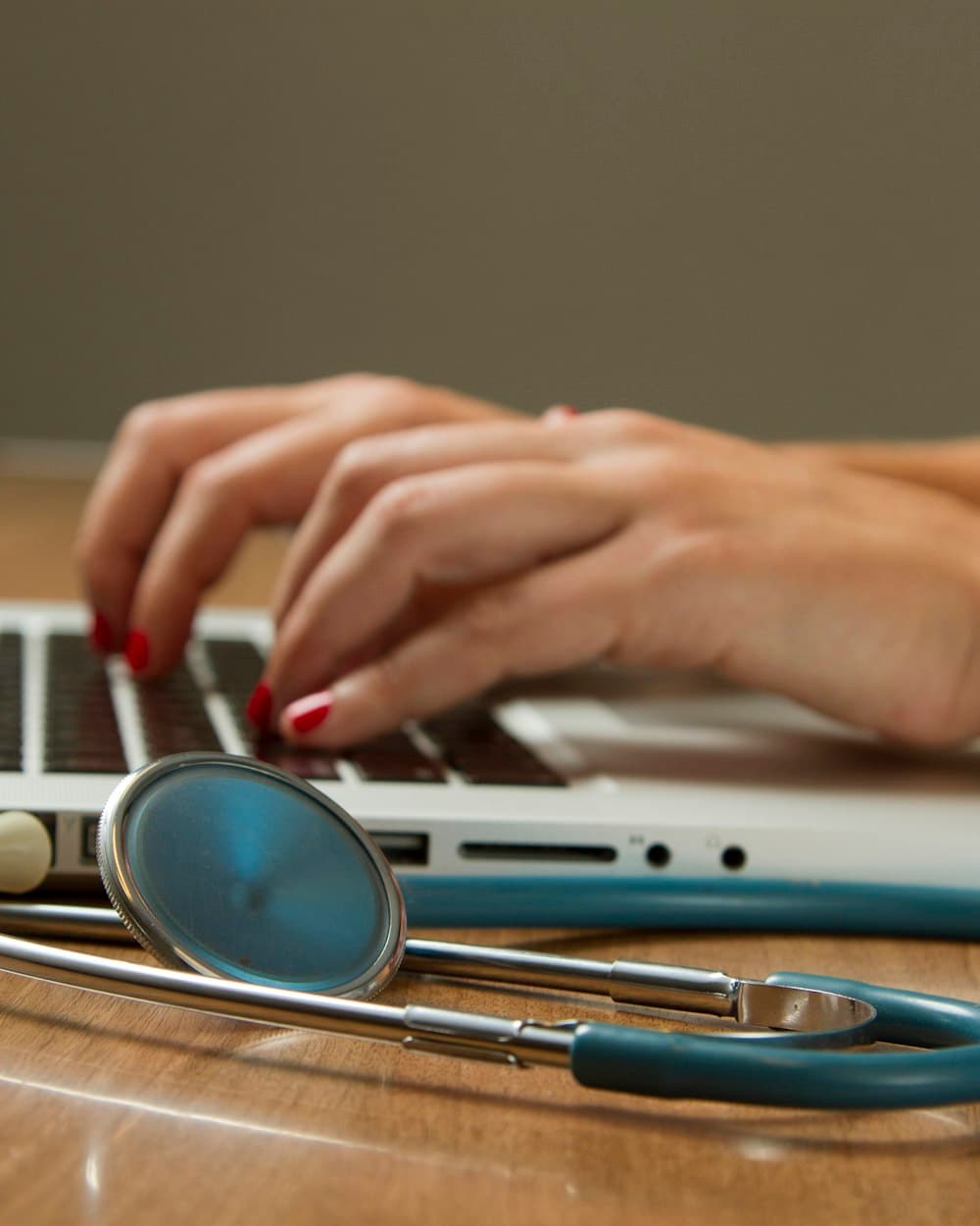 Clinician reviewing patient records on a laptop